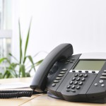 Advanced managerial VoIP phone on beech desk.